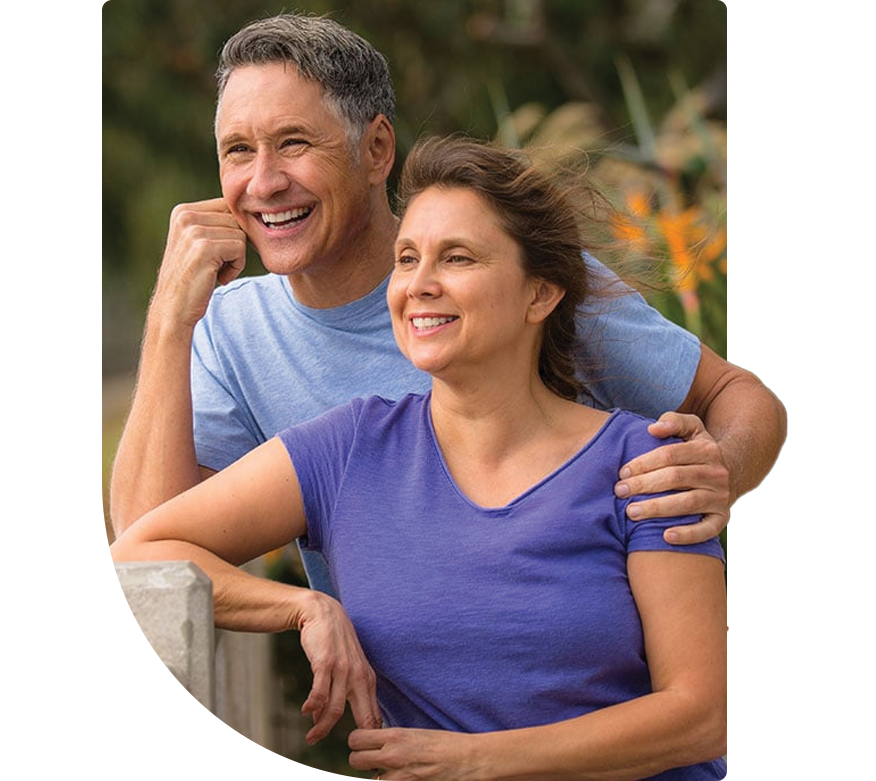 An older couple smiling and looking out at nature