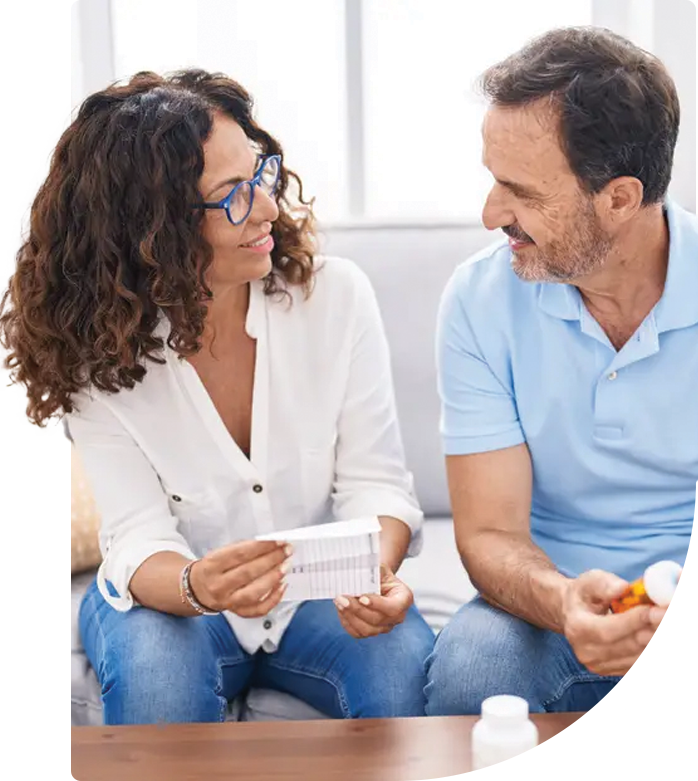 couple at a Calgary pharmacy holding pills and a prescription