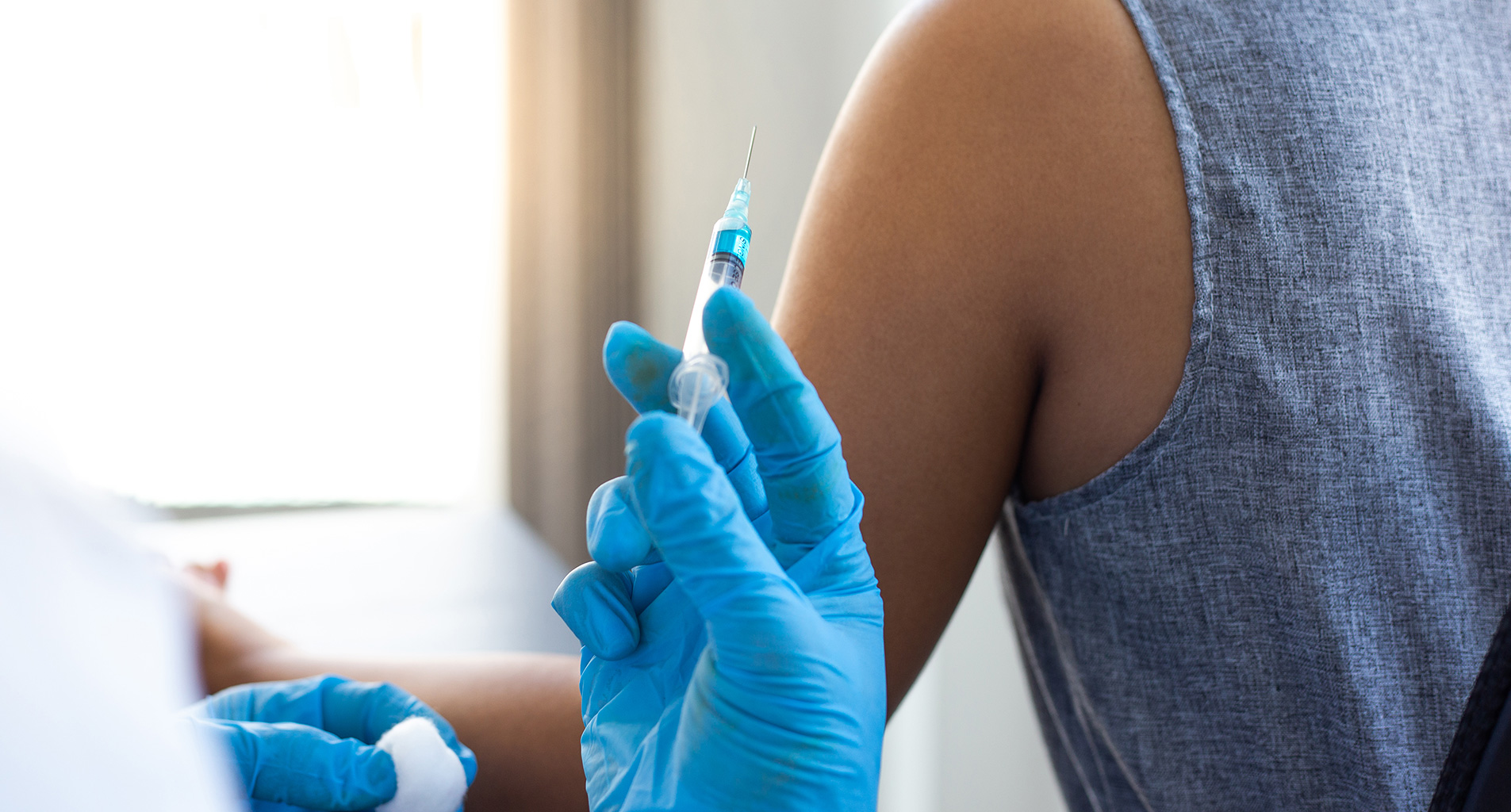 calgary pharmacist about to inject someone with a needle
